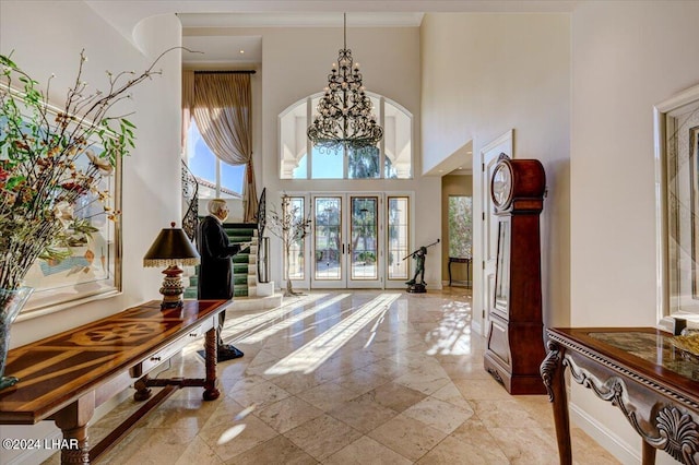 entryway featuring a high ceiling, french doors, and an inviting chandelier