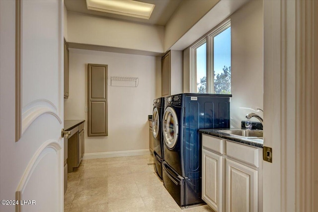 laundry room featuring cabinets, sink, and washing machine and clothes dryer