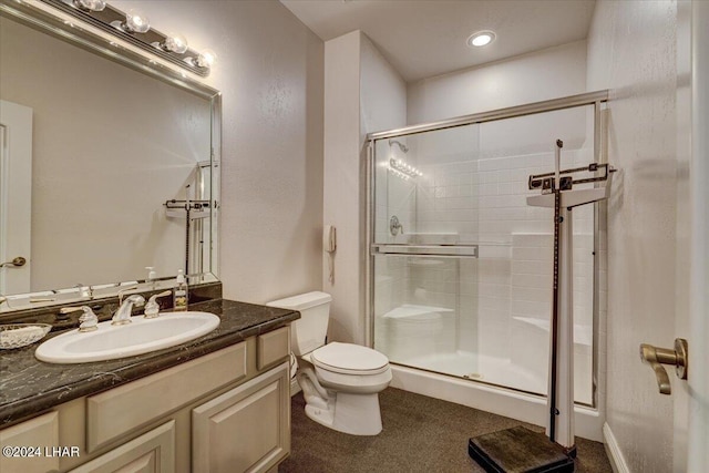 bathroom featuring vanity, toilet, and a shower with shower door