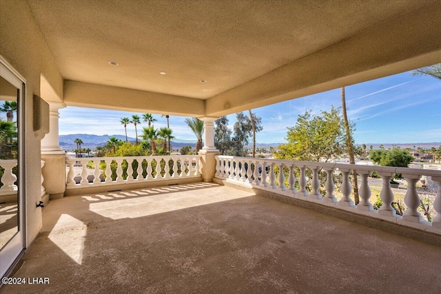 view of patio featuring a balcony and a mountain view