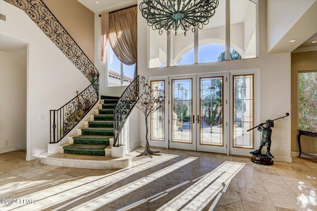 foyer featuring a chandelier, french doors, and a towering ceiling