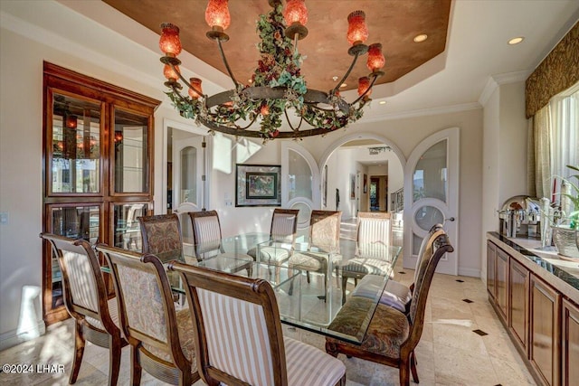 dining room with a tray ceiling and ornamental molding