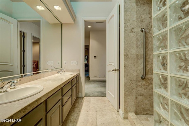 bathroom with a tile shower and vanity