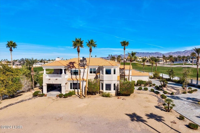 view of front of property with a mountain view and a balcony