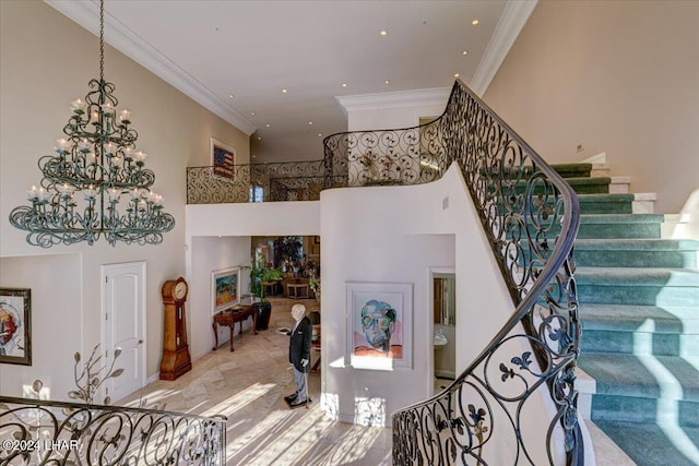 stairway featuring crown molding, a towering ceiling, and an inviting chandelier