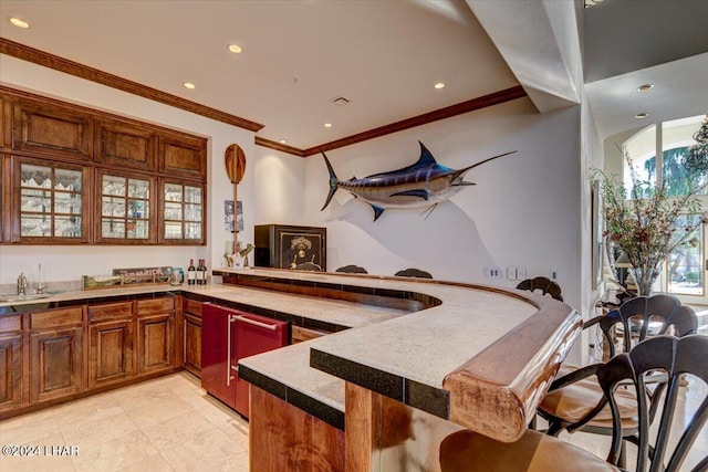 kitchen with sink, kitchen peninsula, and crown molding