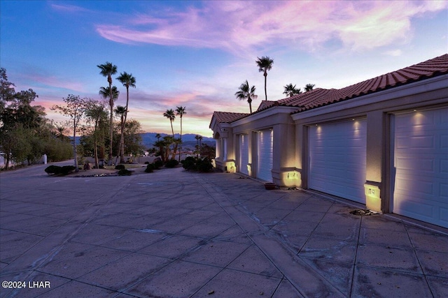 patio terrace at dusk with a mountain view and a garage