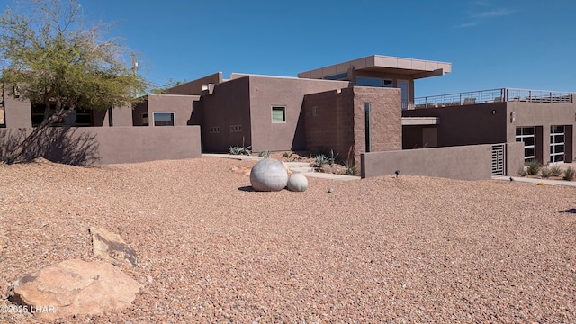view of side of property with stucco siding and fence