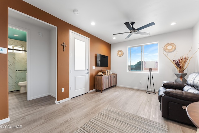 living room with plenty of natural light, light hardwood / wood-style floors, and ceiling fan