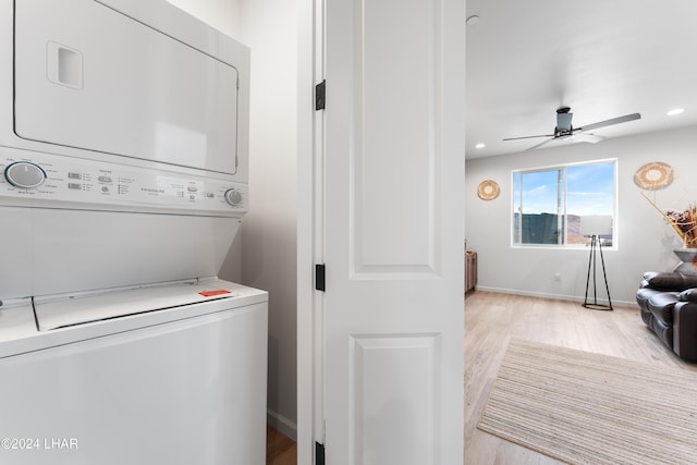 laundry room with radiator, light hardwood / wood-style flooring, ceiling fan, and stacked washing maching and dryer