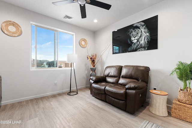 living room featuring ceiling fan and light hardwood / wood-style flooring