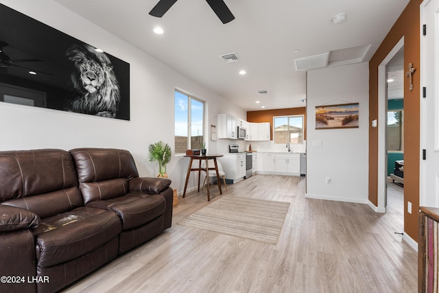 living room featuring sink, ceiling fan, and light hardwood / wood-style flooring