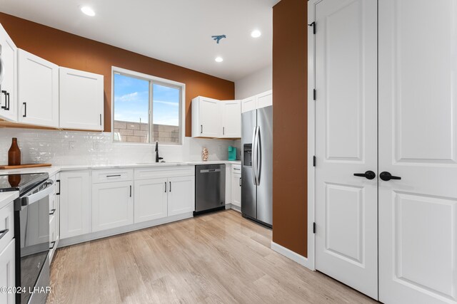 kitchen featuring appliances with stainless steel finishes, sink, white cabinets, and backsplash