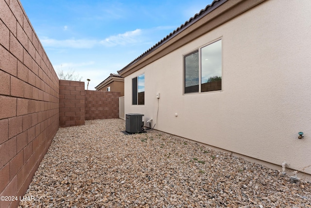 view of side of home with central air condition unit