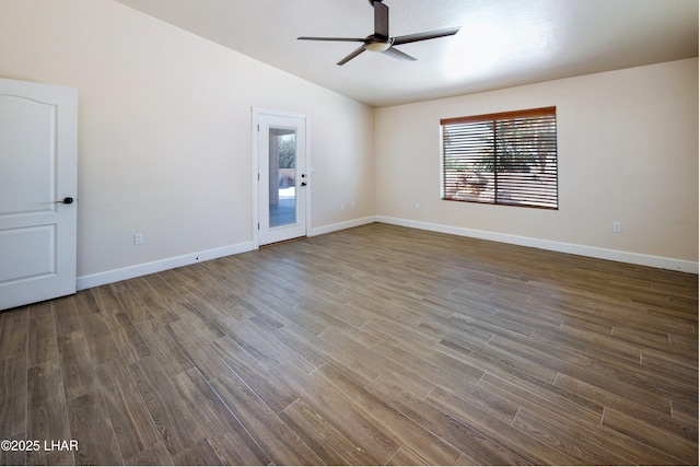 empty room with lofted ceiling, ceiling fan, dark wood-style floors, and baseboards