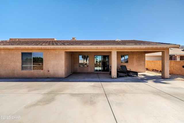 back of house featuring a patio area, fence, and stucco siding