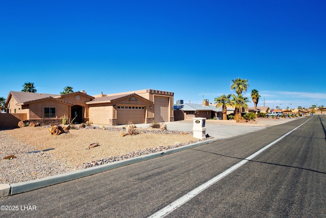 view of front of home with a garage, concrete driveway, a tile roof, and stucco siding