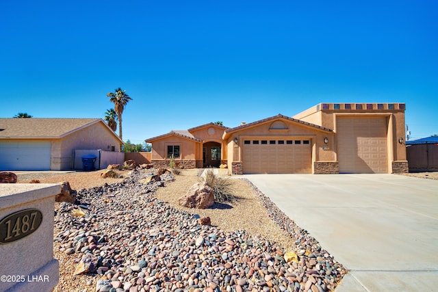 view of front of house featuring a tile roof, stucco siding, concrete driveway, a garage, and stone siding