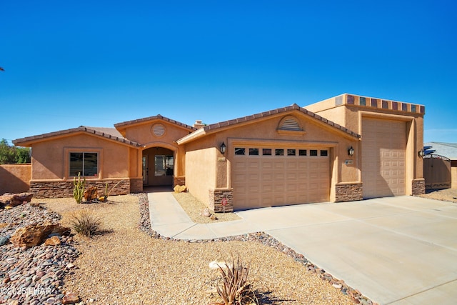 view of front facade with a garage, driveway, stone siding, a tile roof, and stucco siding