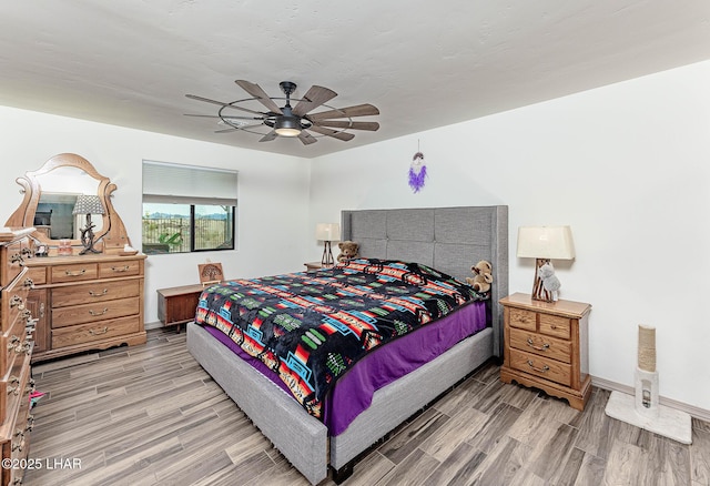 bedroom with baseboards, light wood finished floors, and ceiling fan