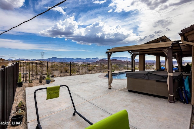 view of patio / terrace with a fenced in pool, a fenced backyard, a hot tub, and a mountain view