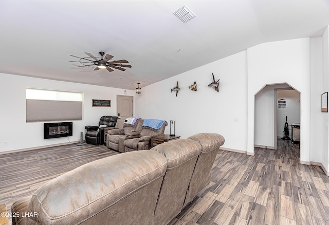 living room with a ceiling fan, arched walkways, visible vents, and wood finished floors