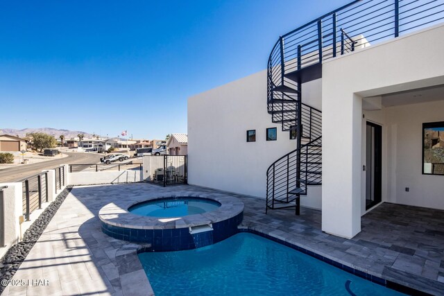 view of swimming pool featuring a mountain view, an in ground hot tub, and a patio area