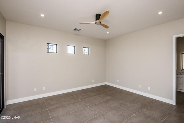 tiled empty room featuring ceiling fan