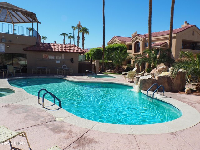 view of pool featuring a community hot tub and a patio area