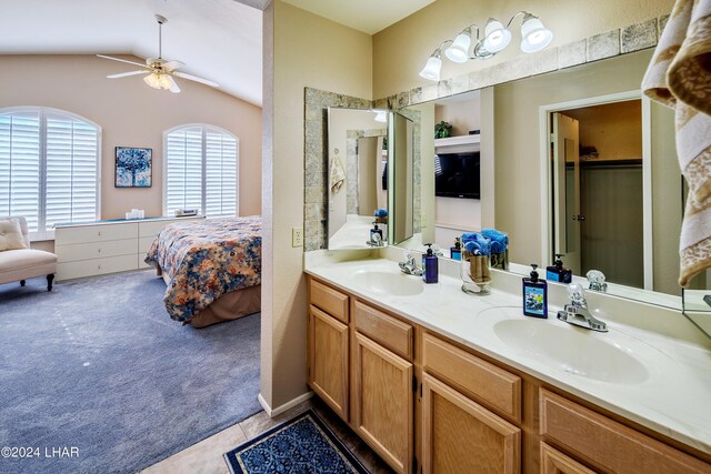 bathroom with tile patterned flooring, vanity, vaulted ceiling, and ceiling fan