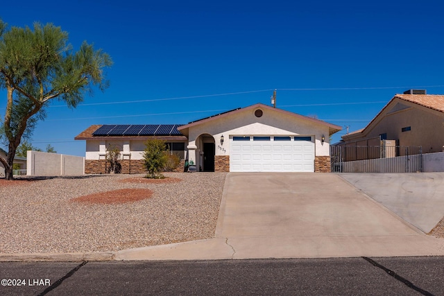 view of front of home with a garage and solar panels