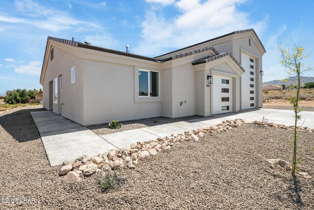 9342 N Broken Saddle Dr, Kingman, AZ 86401 - view of property exterior with concrete driveway, stucco siding, and a garage