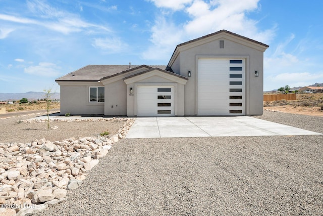 9342 N Broken Saddle Dr, Kingman, AZ 86401 - view of home's exterior featuring concrete driveway, stucco siding, a garage, and a tile roof