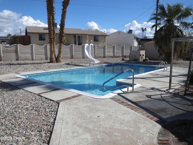 view of pool featuring fence private yard, a fenced in pool, a water slide, and a patio