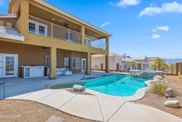 view of swimming pool with an outdoor kitchen, a ceiling fan, fence, a patio area, and a pool with connected hot tub