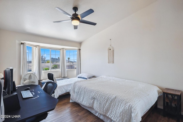 bedroom featuring ceiling fan, dark wood-style flooring, and vaulted ceiling