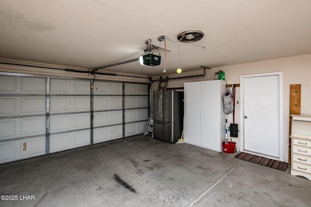 garage featuring a garage door opener and freestanding refrigerator