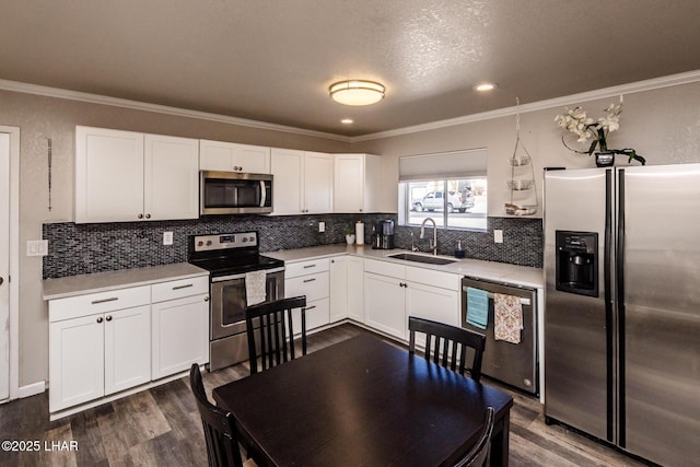 kitchen with stainless steel appliances, white cabinets, light countertops, and a sink