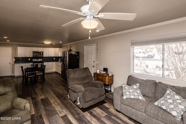 living area featuring dark wood-type flooring, a ceiling fan, and crown molding