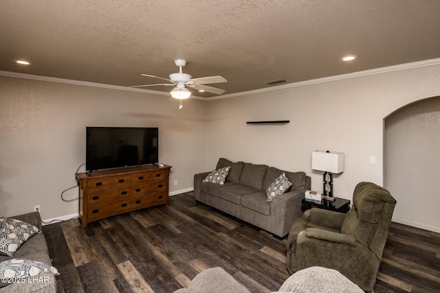 living room with arched walkways, a textured ceiling, visible vents, baseboards, and dark wood finished floors