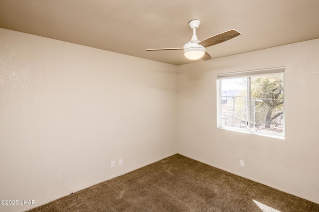 carpeted spare room featuring a ceiling fan