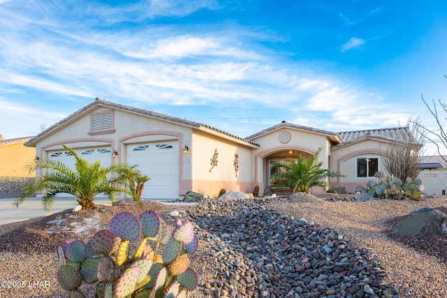 view of front facade with a garage, concrete driveway, and stucco siding