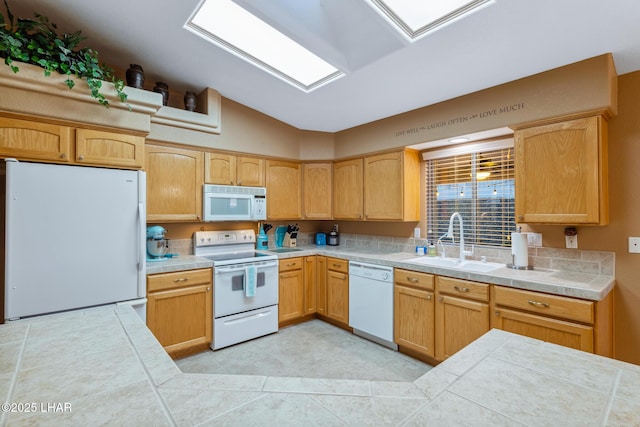 kitchen with tile countertops, light tile patterned flooring, white appliances, a sink, and vaulted ceiling