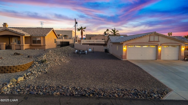 view of front of home with concrete driveway, a tile roof, an attached garage, and stucco siding