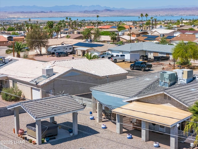 drone / aerial view featuring a water and mountain view and a residential view