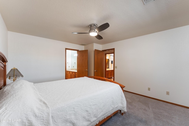 carpeted bedroom featuring visible vents, baseboards, a ceiling fan, and ensuite bath