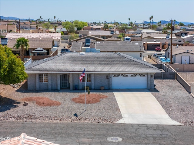 view of front of property with a tile roof, an attached garage, a residential view, and stucco siding