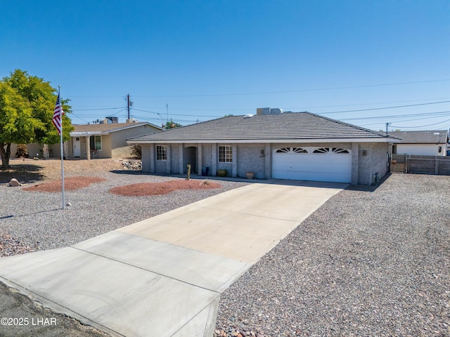 ranch-style house with a tiled roof, stucco siding, fence, an attached garage, and driveway