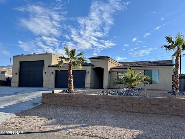 view of front of home with driveway, an attached garage, and stucco siding