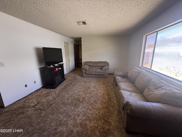 living room with a textured ceiling, visible vents, and carpet